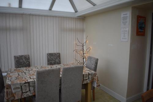 a dining room table with chairs and a lamp at Taldrwst Farmhouse in Dwyran
