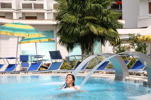 a woman is in a swimming pool in a hotel at Hotel Terme Marconi in Montegrotto Terme