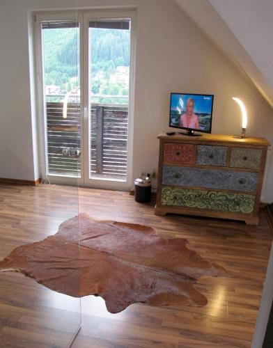 a living room with a large leaf rug on the floor at Club Alpenresidenz Gastein in Bad Gastein