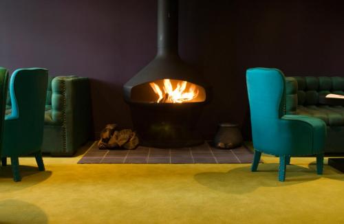 a living room with two chairs and a fire place at Hôtel Ville d'Hiver in Arcachon