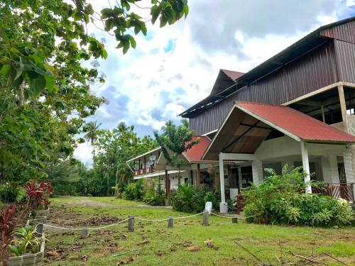 a house with a red roof and a yard at RTMS Guesthouse Semporna in Semporna