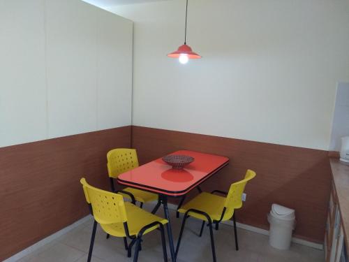 una mesa roja y sillas amarillas en una habitación en TU RINCON EN LA PATAGONIA en San Martín de los Andes