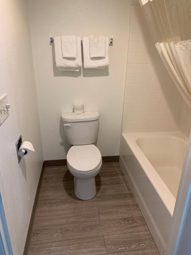a bathroom with a toilet and a bath tub at Travelodge by Wyndham Cedar City in Cedar City