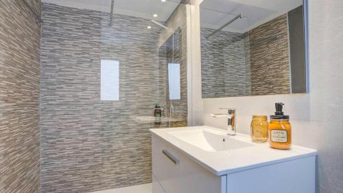 a bathroom with a sink and a shower with a mirror at APARTAMENTO MAGNIFIK in Corralejo