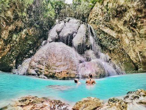 two people in the water near a waterfall at Murals Mactan in Mactan