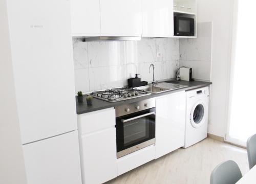 a white kitchen with a stove and a dishwasher at Domus Termini in Rome