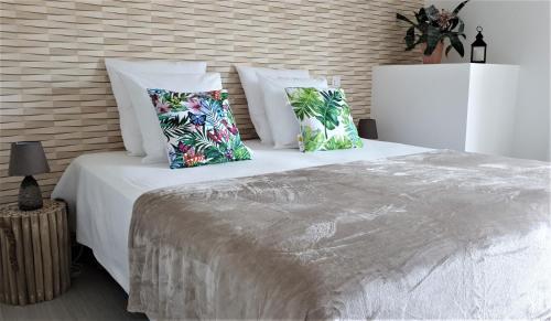 une chambre avec un grand lit blanc avec des oreillers dans l'établissement Hostel les Terrasses du Roc, à Saint-André-de-Roquepertuis