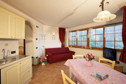 una cucina e un soggiorno con un tavolo e un divano di Villa Gardenia Molveno a Molveno