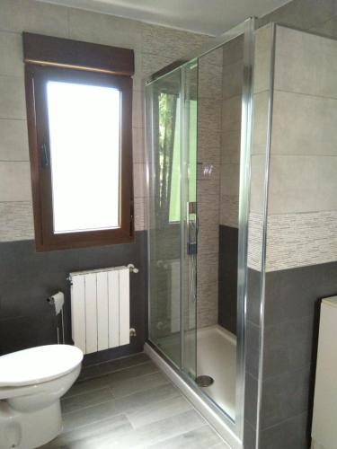 a bathroom with a glass shower and a toilet at El Parador in San Vicente de la Barquera