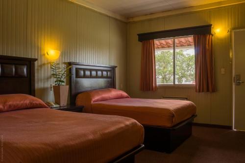 a hotel room with two beds and a window at BONITTO INN® Tampico Altamira in Tampico