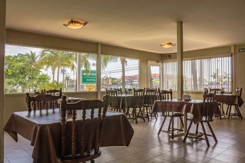 un restaurante con mesas, sillas y ventanas en BONITTO INN® Tampico Altamira, en Tampico