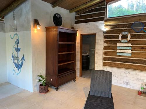 um quarto com um armário de madeira e uma cadeira em Damiro em Piriápolis