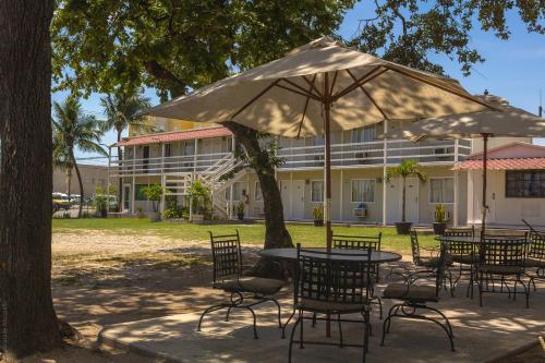 a table and chairs with an umbrella in front of a building at BONITTO INN® Tampico Altamira in Tampico