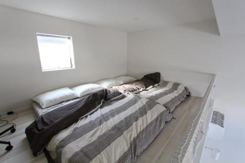 a bed in a white room with a window at Building A101 / Vacation STAY 1277 in Tokyo