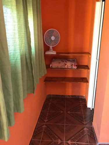 a room with a fan and a tiled floor at Pousada da Vila in Vale do Capao