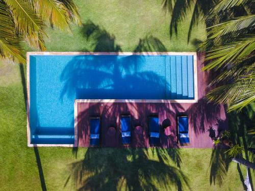 an overhead view of a swimming pool with palm trees at Pousada Vila Cobé in Japaratinga