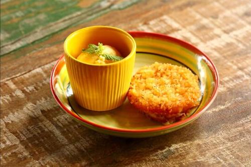 a plate with a muffin and a cup of soup at Pousada Vila Cobé in Japaratinga