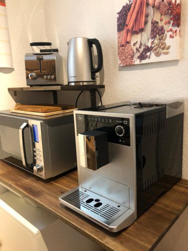 een aanrecht met een magnetron en een koffiezetapparaat bij Apartment Essen Holsterhausen in Essen
