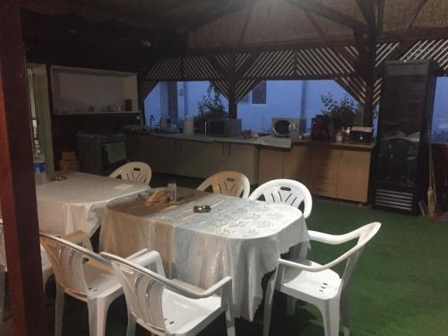 une salle à manger avec deux tables et des chaises blanches dans l'établissement Casa Cleopatra 2 MAI, à 2 Mai