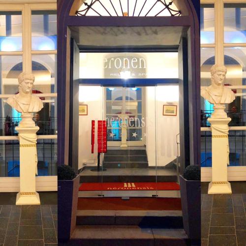 a front door of a store with two statues in it at Hotel Terme Neronensis in Pozzuoli