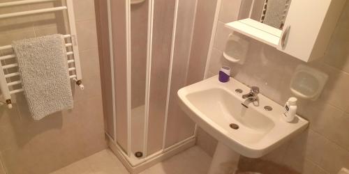 a white bathroom with a sink and a mirror at Borgo Saraceno in Sambuca di Sicilia