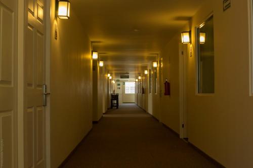 an empty hallway with lights on the walls and a long corridor at BONITTO INN® Tampico Aeropuerto in Tampico