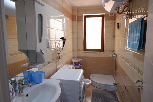 a bathroom with a sink and a toilet at Kings Apartment 4 in Kolgecaj