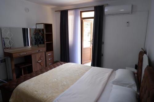 a bedroom with a bed and a dresser and a window at Kings Apartment 4 in Kolgecaj