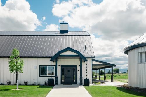 a white barn with a black door and a garage at The Barn B&B Walla Walla in Walla Walla