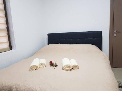 a bed with three towels and flowers on it at Bridge Apartment in Kratovo