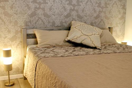 a bedroom with a bed with a pillow and a wall at New! Cozy Apartment with Free guarded parking in Rīga