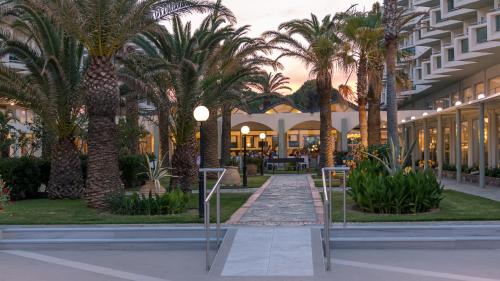 a building with palm trees and a walkway at Apollo Beach in Faliraki