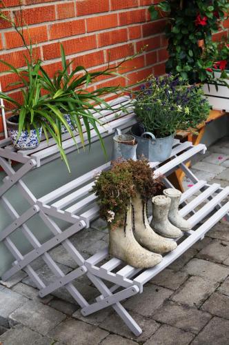 a white bench with potted plants on it at Eriks Bädd och Pentry in Hillerstorp