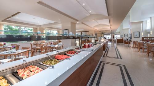 a buffet line in a restaurant with tables and chairs at Apollo Beach in Faliraki