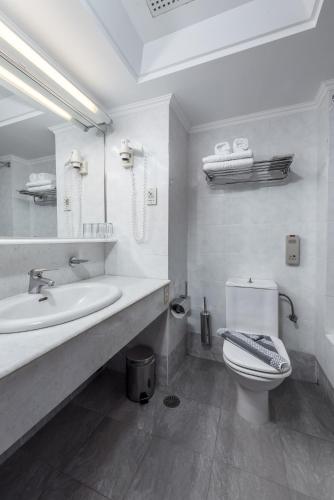 a white bathroom with a sink and a toilet at Apollo Beach in Faliraki