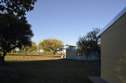 a house with a yard next to a building at Entre Acequias in General Alvear