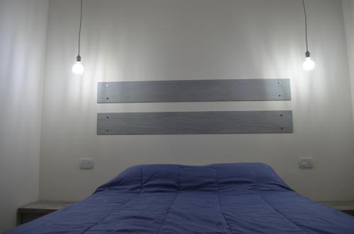 a bed in a bedroom with two lights above it at Entre Acequias in General Alvear