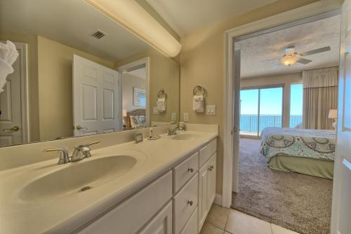 uma casa de banho com um lavatório, um espelho e uma cama em Comfortable High-Rise Condo with Beach Access - Unit 1404 em Panama City Beach