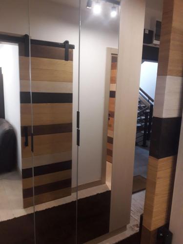 a glass door with a mirror in a room at Kamena Kuca Lux Apartment in Kopaonik