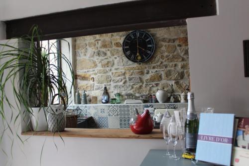 a clock on a stone wall above a kitchen counter at L'Albane Chambres d'hôtes in Lauraguel