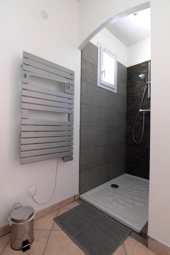 une salle de bain avec une douche avec une porte vitrée dans l'établissement Villa Louanne, à Pertuis