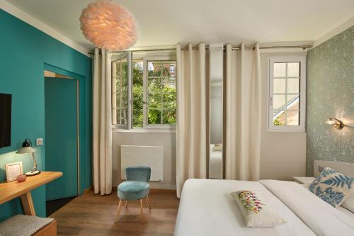 a bedroom with a bed and a chair and a window at Le Vert Galant - Auberge Etchegorry in Paris