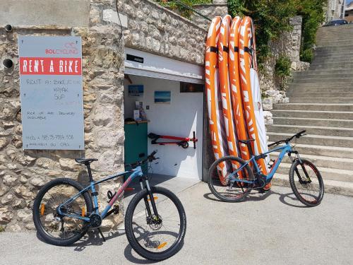 dos bicicletas estacionadas frente a un edificio con una tabla de surf en Accommodation Stella Mare en Bol