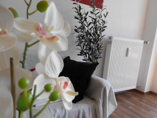 a couch with white flowers and a black pillow at Apartment Beethoven in Regensburg
