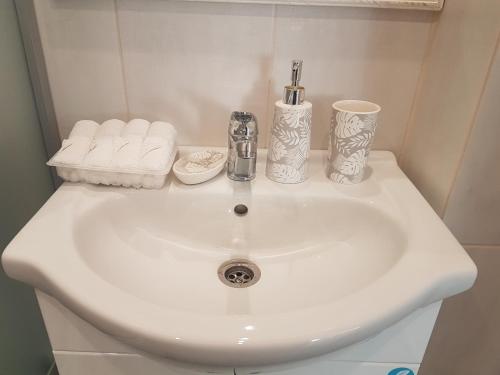 lavamanos blanco con toallas y cepillo de dientes en Vanilla Sky Apartments, en Sillamäe