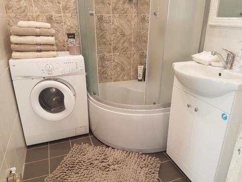 a bathroom with a washing machine and a sink at Vanilla Sky Apartments in Sillamäe