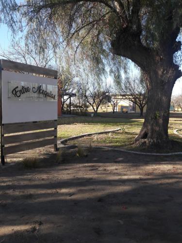a sign for a park with a tree in the background at Entre Acequias in General Alvear