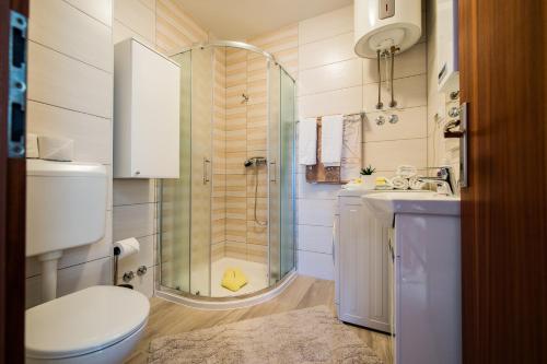 een badkamer met een douche, een toilet en een wastafel bij Apartments Bongavila in Podstrana