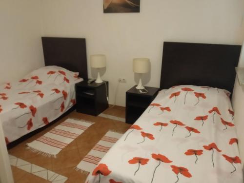 een slaapkamer met 2 bedden met rode bladeren op de lakens bij Rooms Lutra in Bilje