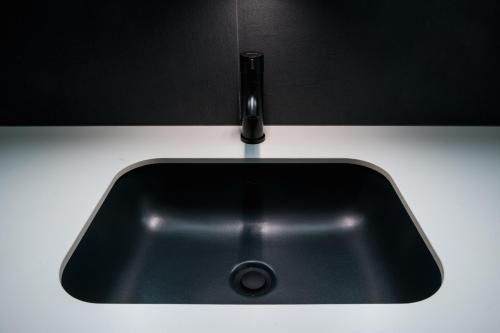a black sink with a faucet on a counter at Maestro Design Hotel in Liepāja